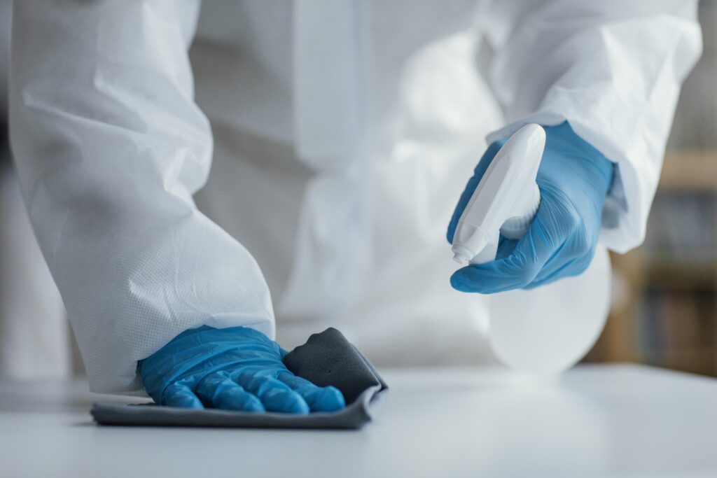 person disinfecting biohazard area